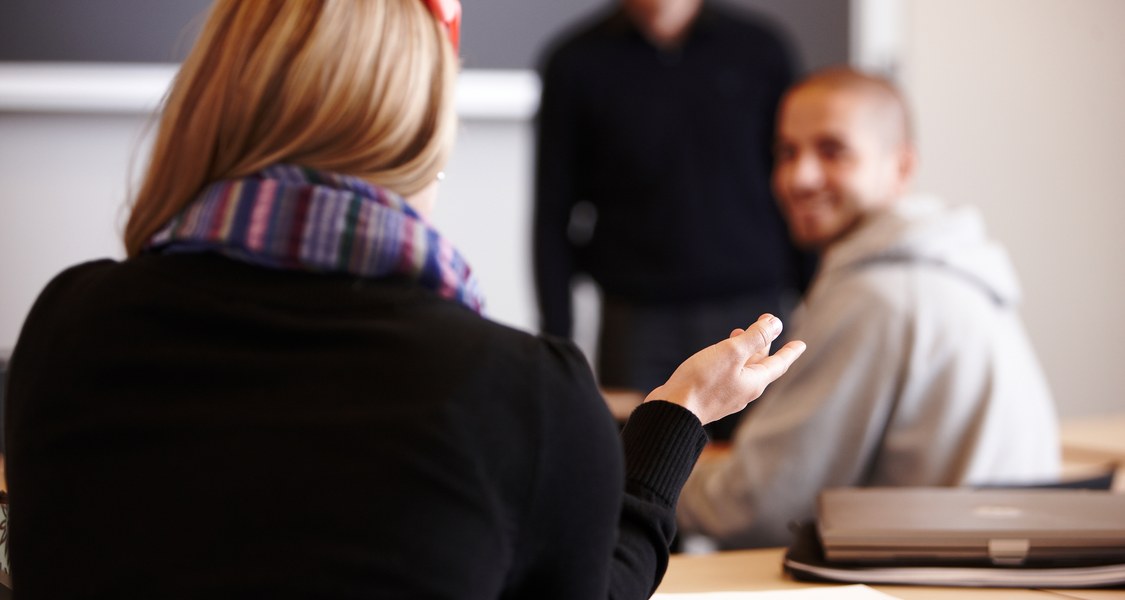 Studierende diskutieren miteinander im Seminarraum