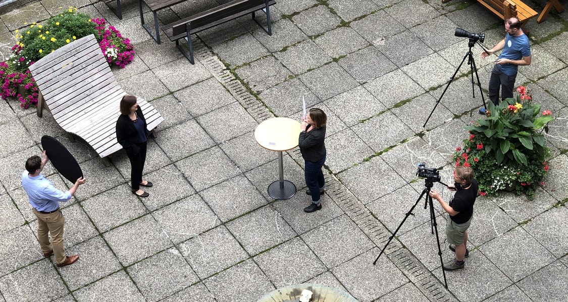 Links stehend Prof. Beinhauer-Köhler, in der Mitte des Bildes Interviewerin, rechts zwei Personen mit Kameras