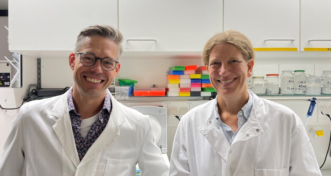 Die Forschenden Robert Junker und Nina Farwig im Labor, vor Laborschränken