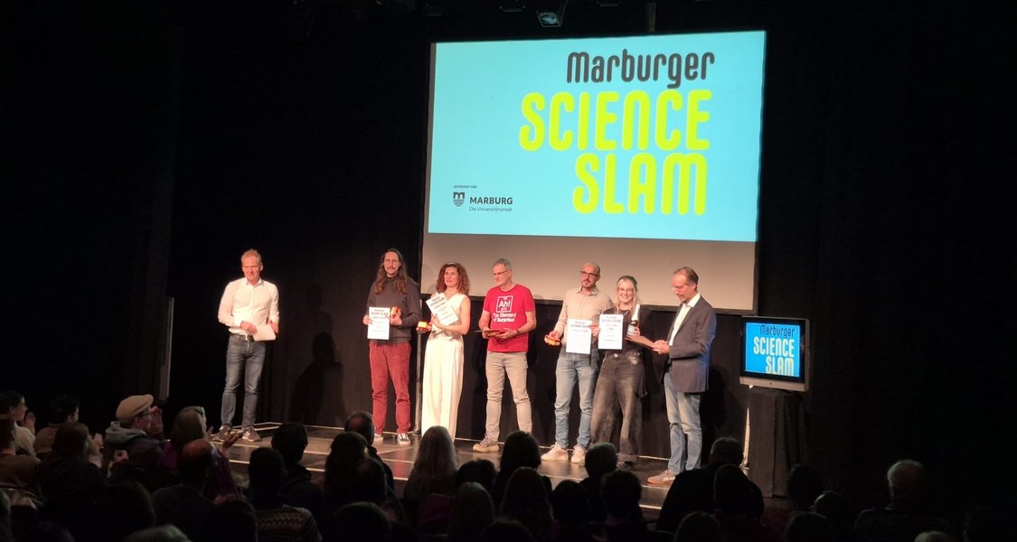 Menschen auf der Bühne zur Preisverleihung des Science Slams