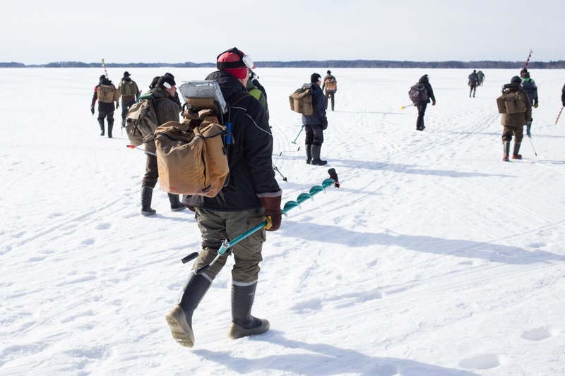 Eisfischer*innen auf einem zugefrorenen See in Finnland