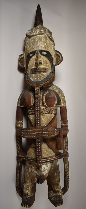 Uli Figur mit weiblichen und männlichen Geschlechtsmerkmalen. Material: Holz, mit Kalkfarben bemalt, Kokosnussfaser, Muschelschale.