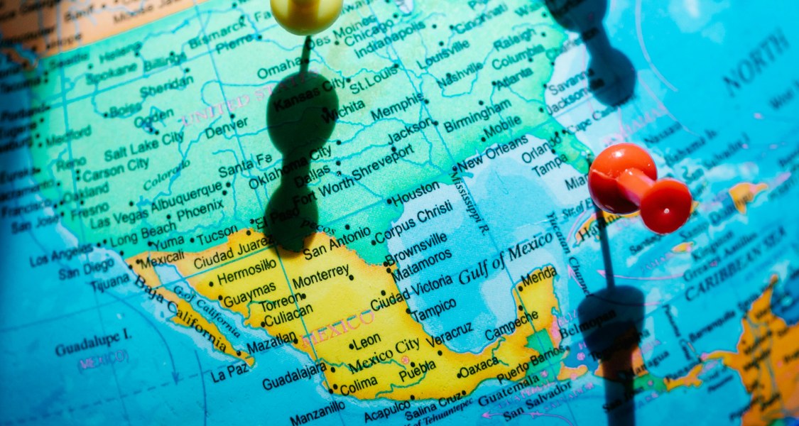 Eine Landkarte Amerikas mit verschiedenen farbigen Pins, die Reiseziele markieren.