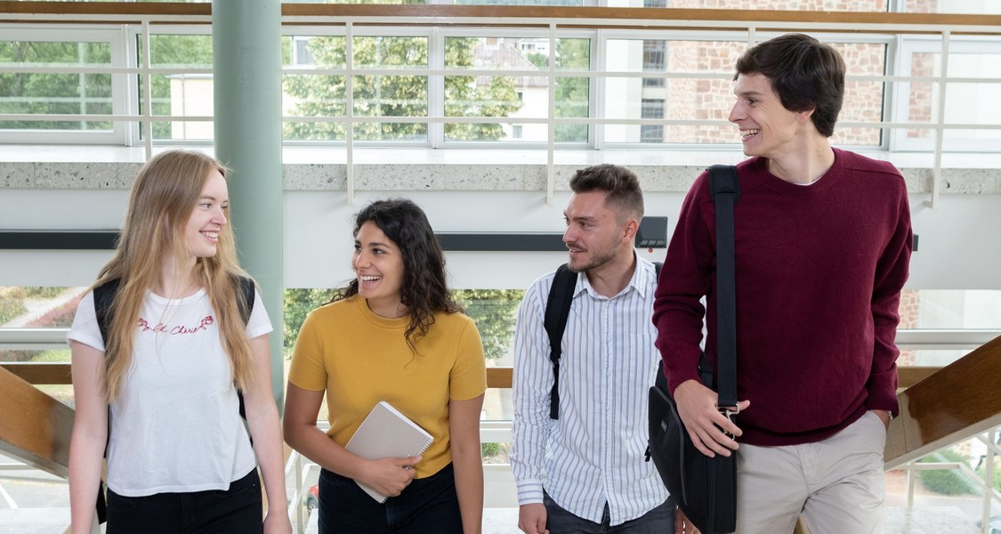 Vier Studierende steigen eine Treppe nach oben.