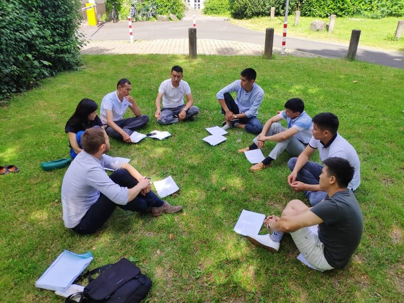 Students sitting in the gras talking.