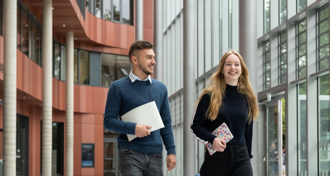 Zwei Studierende laufen durch die UB