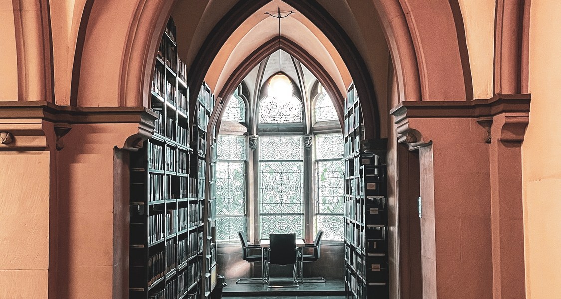 Bücheregale und Sitzgruppe am Fenster in der Bibliothek Evangelische Theologie