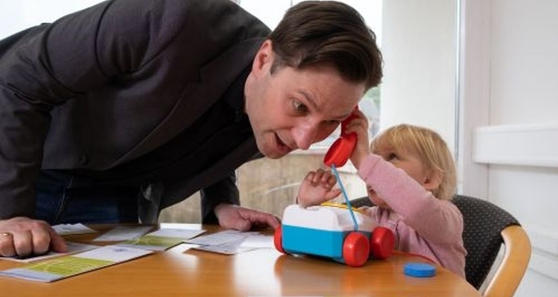 Kind und Vater spielen mit Kindertelefon.